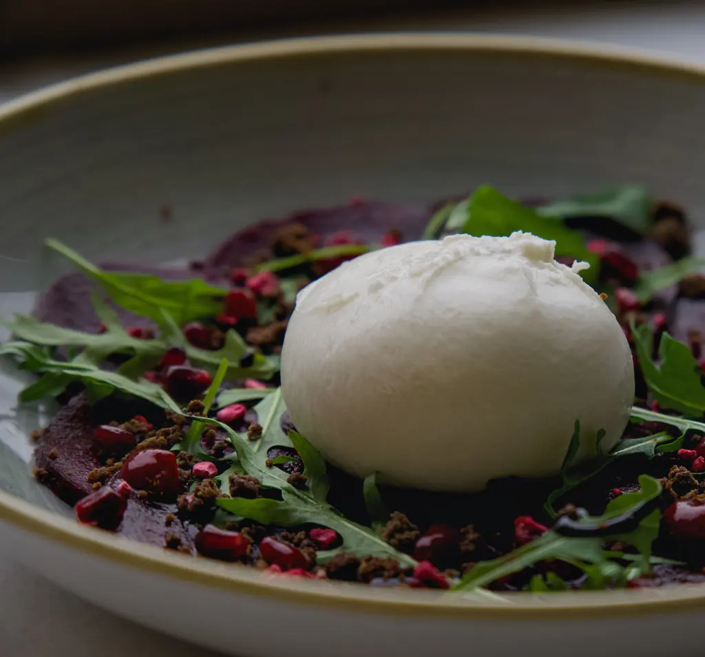 Burrata på rödbetscarpaccio med ruccola och granatäpple.