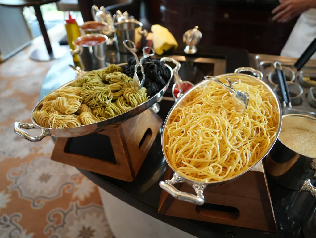 Pastastation med två kopparpannor färsk pasta.